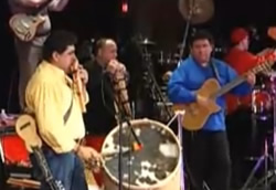 Marco Mallea is in blue playing the guitar and Andres Mallea is on the panpipes.